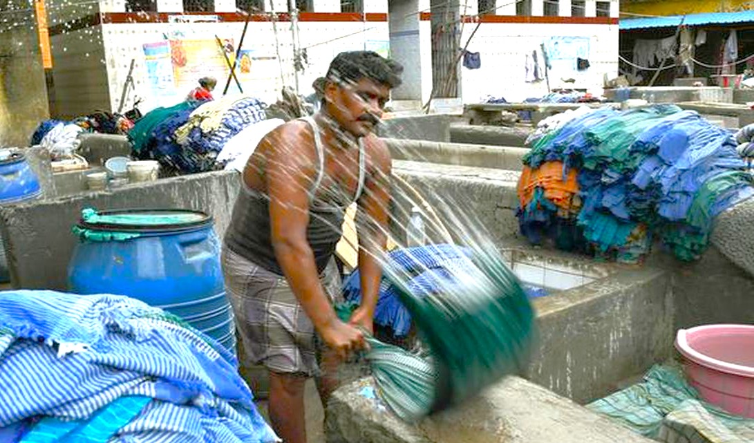 At Dhoby Khana Laundry in Kochi, Kerala, South India, local washers hand-wash and thrash hundreds of garments daily in open stone vats, preserving a century-old communal tradition, authentic cultural experience. At Dhoby Khana Laundry in Kochi, Kerala, South India, local washers hand-wash and thrash hundreds of garments daily in open stone vats, preserving a century-old communal tradition, authentic cultural experience.