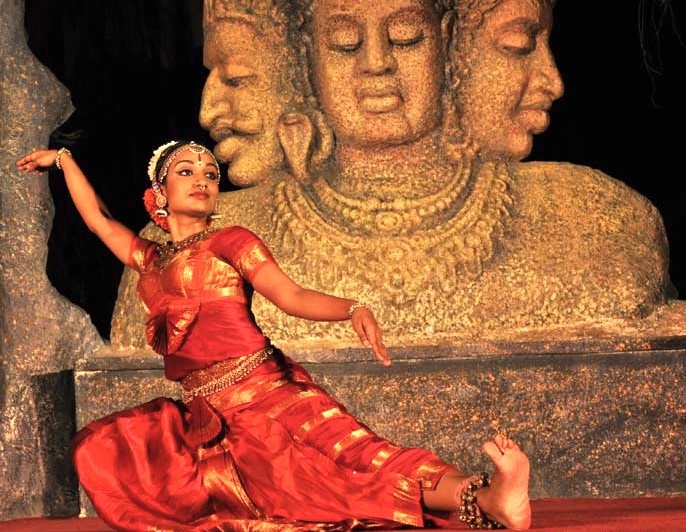 Traditional Bharatanatyam dancer in vibrant red costume performs before ancient rock-cut relief at Elephanta Caves festival near Mumbai in Mahapradesh, India, celebrating Sanskrit heritage, UNESCO World Heritage Site, cultural tourism. Traditional Bharatanatyam dancer in vibrant red costume performs before ancient rock-cut relief at Elephanta Caves festival near Mumbai in Mahapradesh, India, celebrating Sanskrit heritage, UNESCO World Heritage Site, cultural tourism.