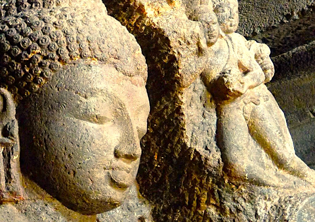 Weathered stone Buddha sculptures carved into basalt walls at UNESCO World Heritage Elora and Ajanta Caves near Aurangabad, Maharashtra, India, reveal exquisite intricate carvings, craftsmanship, archaeological significance, serene historical ambiance.