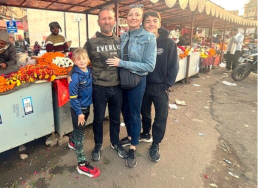A smiling tourist family enjoys a local flower market, a popular stop for visitors to the Floating Market in Srinagar, Jammu and Kashmir, India.