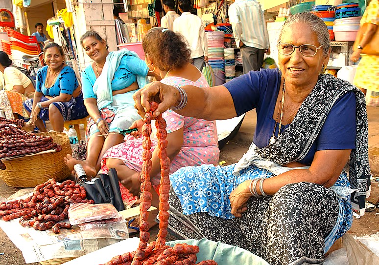 Local women sell goods at the Goa Flea Market in India, a vibrant experience alongside visiting beaches, Fontainhas (Portuguese Quarter), and the Old Goa-Bom Jesus Bassilica-Unesco churches. Local women sell goods at the Goa Flea Market in India, a vibrant experience alongside visiting beaches, Fontainhas (Portuguese Quarter), and the Old Goa-Bom Jesus Bassilica-Unesco churches.
