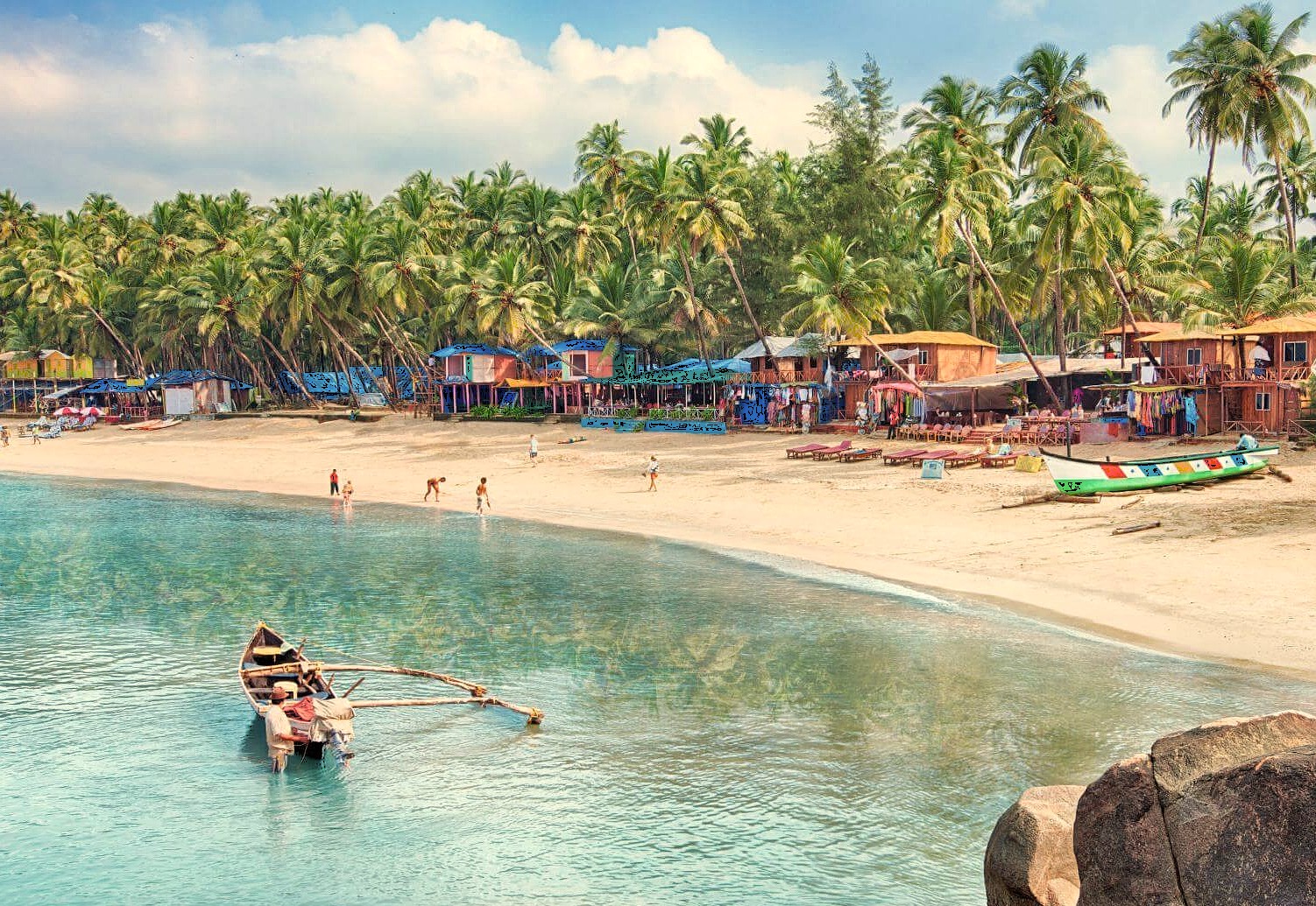 A traditional boat rests in calm turquoise water off the sandy Goa Beaches, India, lined with palm trees and shacks, located near Karnataka and the Old Goa St. Francis Church UNESCO churches. A traditional boat rests in calm turquoise water off the sandy Goa Beaches, India, lined with palm trees and shacks, located near Karnataka and the Old Goa St. Francis Church UNESCO churches.