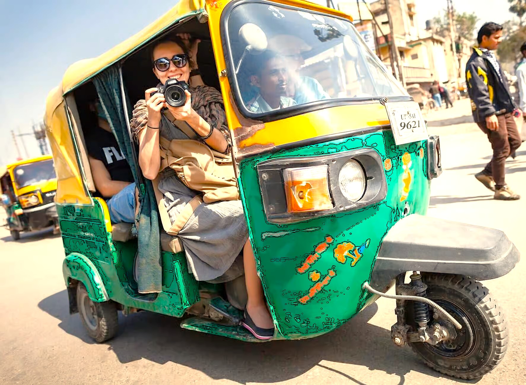 A smiling tourist with a camera enjoys an auto-rickshaw ride in Goa, India. This popular region, famous for its beaches, is located near Karnataka and the historic Old Goa St. Francis Church UNESCO churches. A smiling tourist with a camera enjoys an auto-rickshaw ride in Goa, India. This popular region, famous for its beaches, is located near Karnataka and the historic Old Goa St. Francis Church UNESCO churches.
