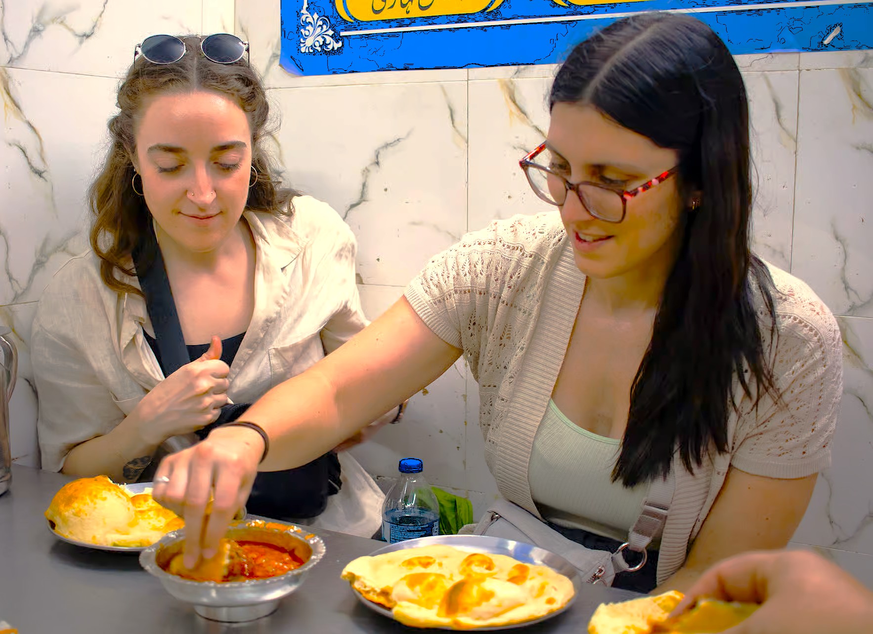Two travelers enjoy local cuisine in a casual eatery near Grishneshwar Temple in Aurangabad, Maharashtra, India, exploring culinary delights between visits to the UNESCO Ellora and Ajanta Caves pilgrimage circuit.