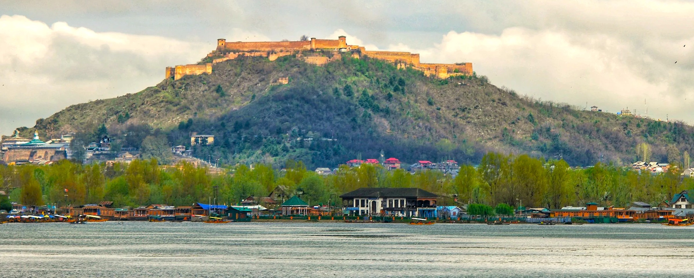 Scenic view of the historic Hari Parbat Fort overlooking Dal Lake houseboats, a famous landmark and tourist destination in Srinagar, Jammu and Kashmir, India.