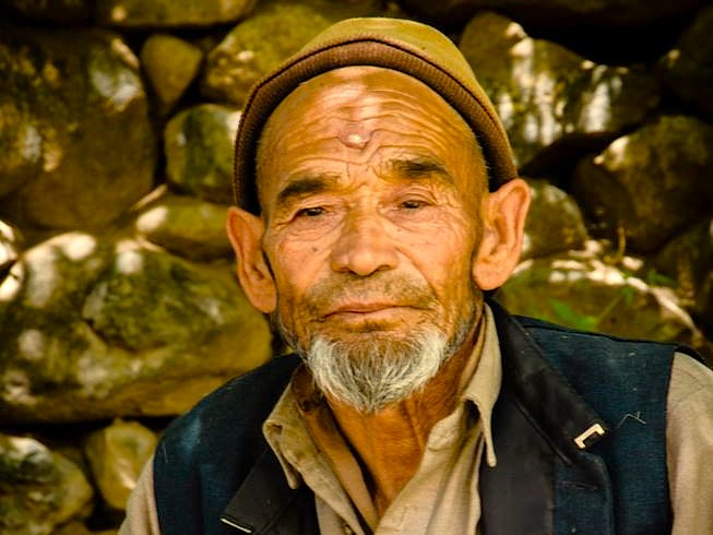 Close-up portrait of an elderly Kashmiri man in a traditional cap, representing the local culture near Hari Parbat Fort in Srinagar, Jammu and Kashmir, India.