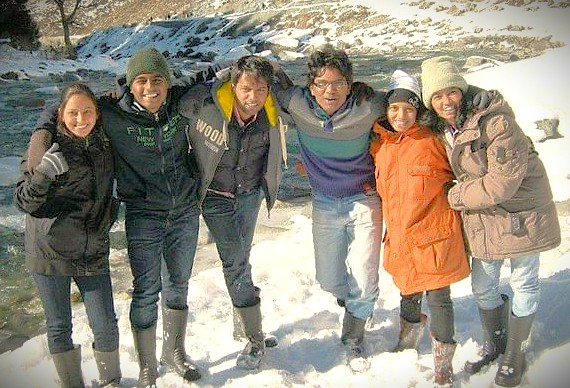 A group of happy tourists enjoys the snow near Hari Parbat Fort, a popular winter travel destination for friends in Srinagar, Jammu and Kashmir, India.