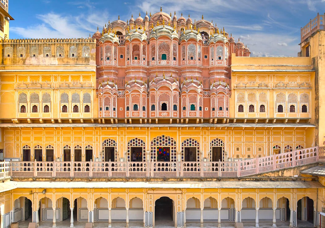 Spacious interior hall of UNESCO-listed Hawa Mahal – Palace of the Winds in Jaipur, Rajasthan, India featuring pink sandstone arches, ornate lattice windows, ambient light filtering through jharokhas, Mughal-inspired heritage.