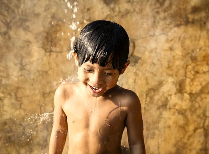 A local boy enjoys playing in the water near Hemakuta Hill and the Kadalekalu Ganesha at the Hampi, Karnataka, India UNESCO World Heritage Site. A local boy enjoys playing in the water near Hemakuta Hill and the Kadalekalu Ganesha at the Hampi, Karnataka, India UNESCO World Heritage Site.