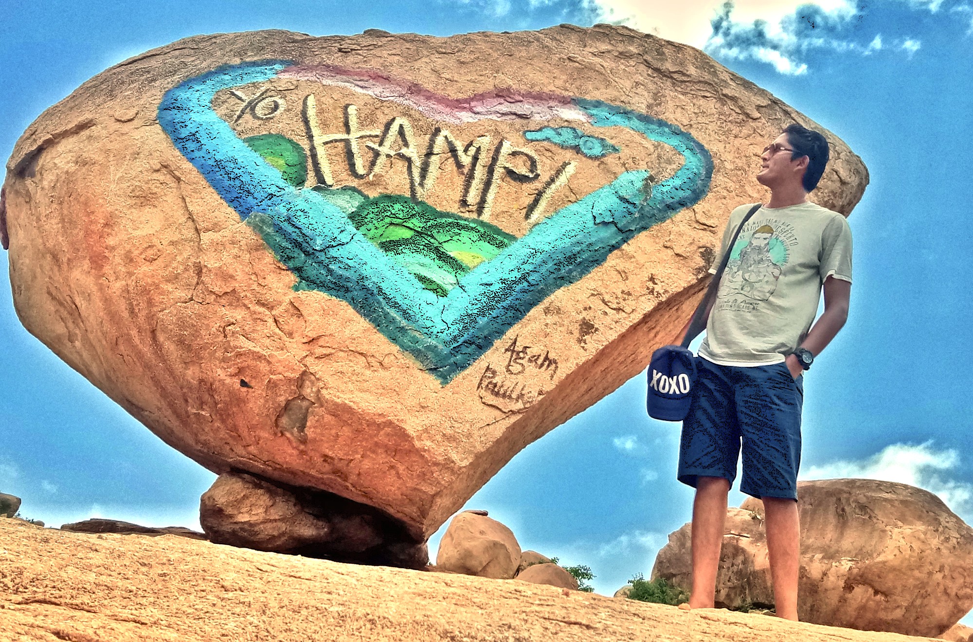 A tourist poses by the famous 'I Love Hampi' rock sign near Hippie Island, a UNESCO site in Karnataka, India, near Sanapur Lake, Vittala Temple, and Queen's Baths. A tourist poses by the famous 'I Love Hampi' rock sign near Hippie Island, a UNESCO site in Karnataka, India, near Sanapur Lake, Vittala Temple, and Queen's Baths.