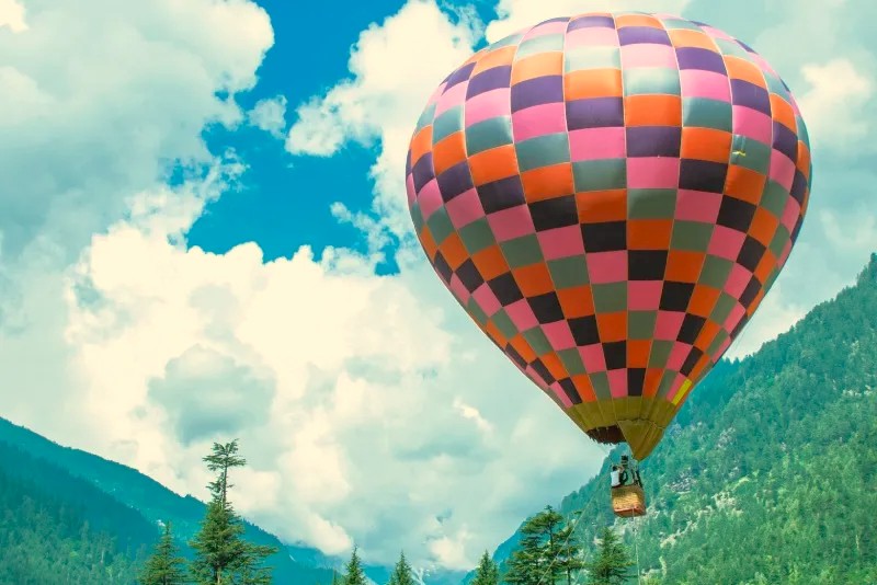 Experience Hot Air Ballooning Srinagar, a colorful balloon over the mountains of Jammu and Kashmir, India, a popular adventure for tourists visiting nearby Nigeen Lake or taking a Nehru Ghat shikara boat tour.