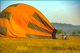 The colorful hot air balloon envelope is laid out for inflation on a field, marking the start of a Hot Air Ballooning Srinagar adventure, a thrilling activity near Nigeen Lake in Jammu and Kashmir, India.