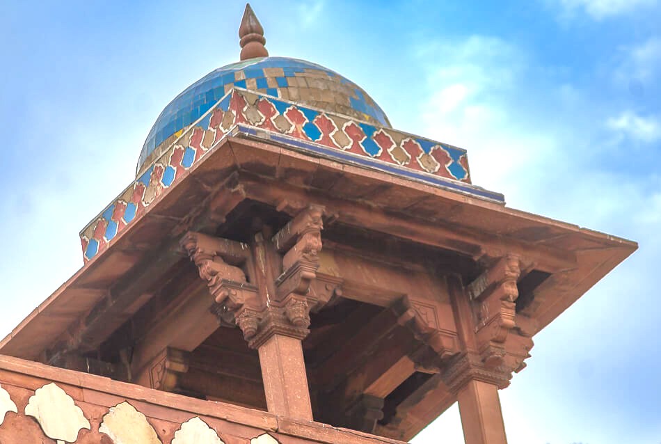 Elaborately carved red sandstone pavilion beneath a vibrant blue mosaic dome at UNESCO World Heritage Humayun’s Tomb in New Delhi, India, exemplifying Mughal Indo-Islamic architecture amid manicured gardens and sky. Elaborately carved red sandstone pavilion beneath a vibrant blue mosaic dome at UNESCO World Heritage Humayun’s Tomb in New Delhi, India, exemplifying Mughal Indo-Islamic architecture amid manicured gardens and sky.