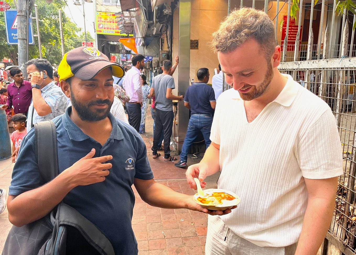 Tourist sampling spicy dahi puri from local vendor beside bustling lanes near Humayun’s Tomb in New Delhi, India, capturing vibrant street food culture, friendly interaction, and authentic historical heritage fusion. Tourist sampling spicy dahi puri from local vendor beside bustling lanes near Humayun’s Tomb in New Delhi, India, capturing vibrant street food culture, friendly interaction, and authentic historical heritage fusion.