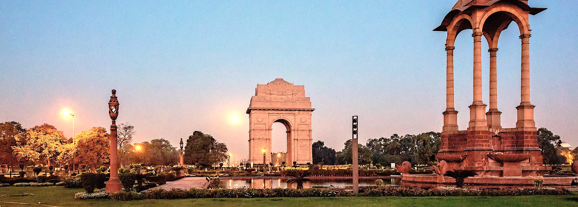 A panoramic dusk view of India Gate in Delhi, India, a top tourist site near the Red Fort and UNESCO World Heritage sites Humayun's Tomb and Qutub Minar.