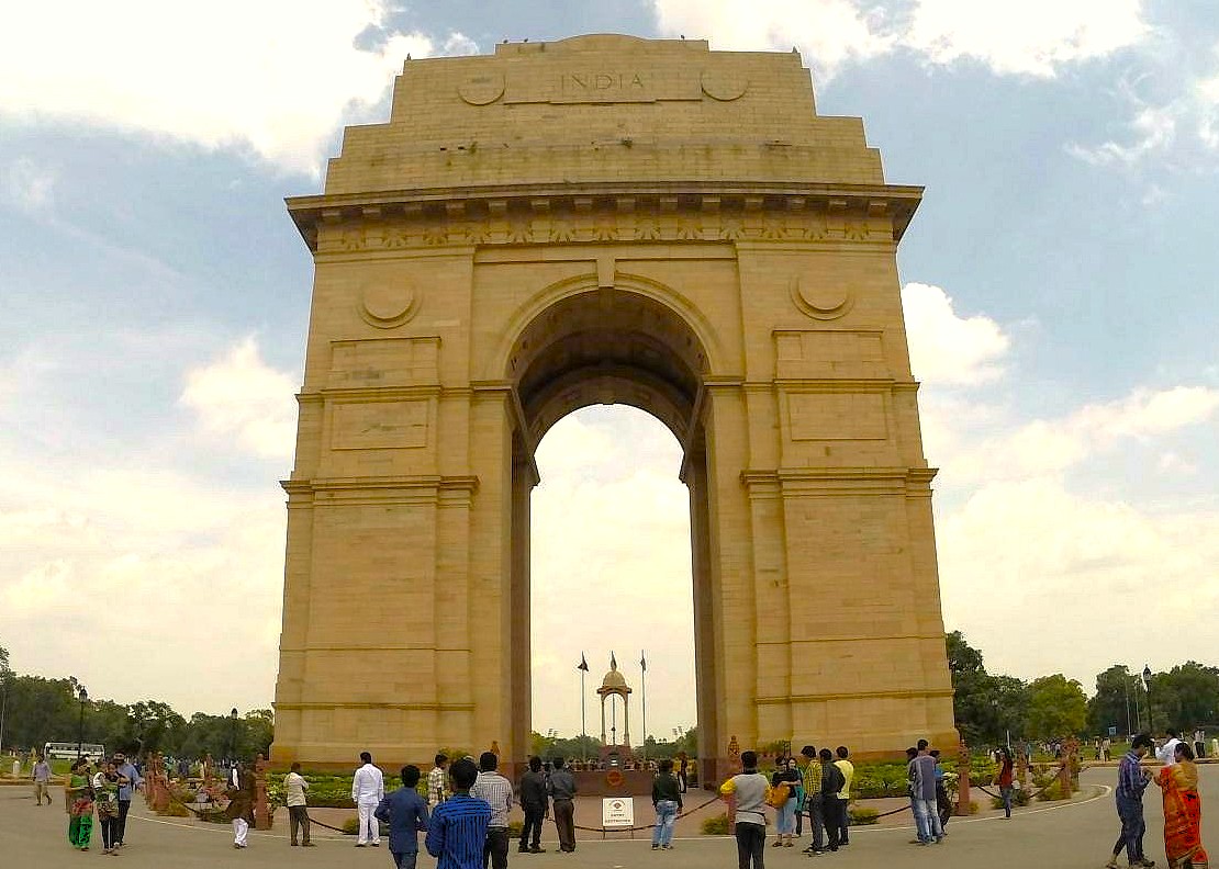 A ground-level view of tourists at the historic India Gate in Delhi, India, a prominent war memorial landmark near UNESCO World Heritage sites like the Red Fort and Humayun's Tomb. A ground-level view of tourists at the historic India Gate in Delhi, India, a prominent war memorial landmark near UNESCO World Heritage sites like the Red Fort and Humayun's Tomb.