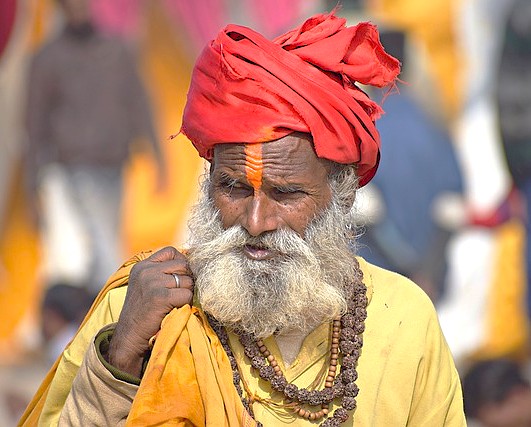 “Discover an elderly sage in traditional Rajasthani attire at the UNESCO World Heritage Jantar Mantar in Jaipur, Rajasthan, India, adorned with ritual markings, vibrant turban, prayer beads, and festive surroundings.”