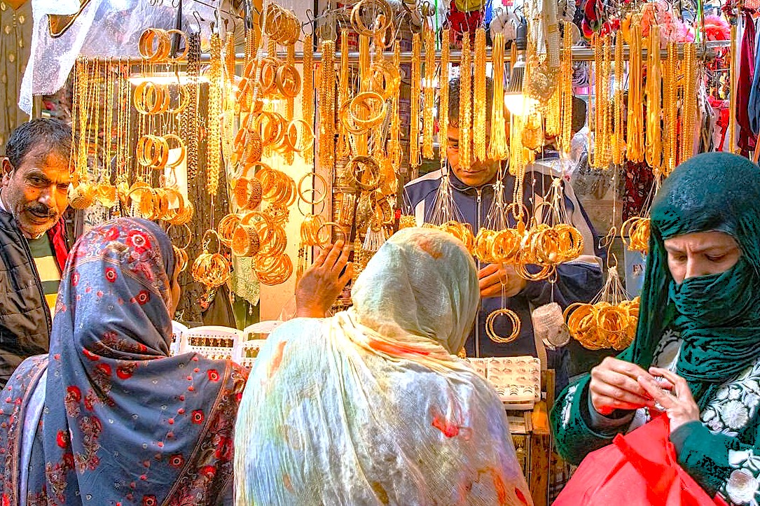Local women shop for brass and gold bangles in a bustling market in Kashmir-Srinagar, India, showcasing the city's commerce near the controversial Jesus Tomb and Shankaracharya Hill, set against the distant Himalayas, reflecting the region's rich culture. Local women shop for brass and gold bangles in a bustling market in Kashmir-Srinagar, India, showcasing the city's commerce near the controversial Jesus Tomb and Shankaracharya Hill, set against the distant Himalayas, reflecting the region's rich culture.