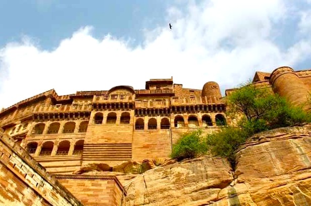 Majestic Mehrangarh Fort overlooking Jodhpur, the Blue City in Rajasthan, India, framed by rugged sandstone cliffs and the vast Thar Desert, symbolizing centuries of royal heritage and timeless architectural grandeur. Majestic Mehrangarh Fort overlooking Jodhpur, the Blue City in Rajasthan, India, framed by rugged sandstone cliffs and the vast Thar Desert, symbolizing centuries of royal heritage and timeless architectural grandeur.