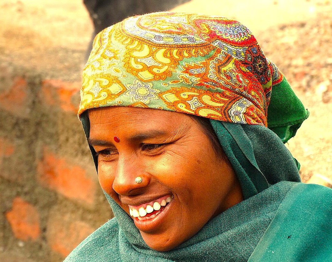 Vibrant portrait of a smiling Indian woman in traditional attire at Aurangabad’s Kailasa Temple, part of the UNESCO-listed Ellora and Ajanta Caves in Maharashtra, India, showcasing a rich cultural heritage.