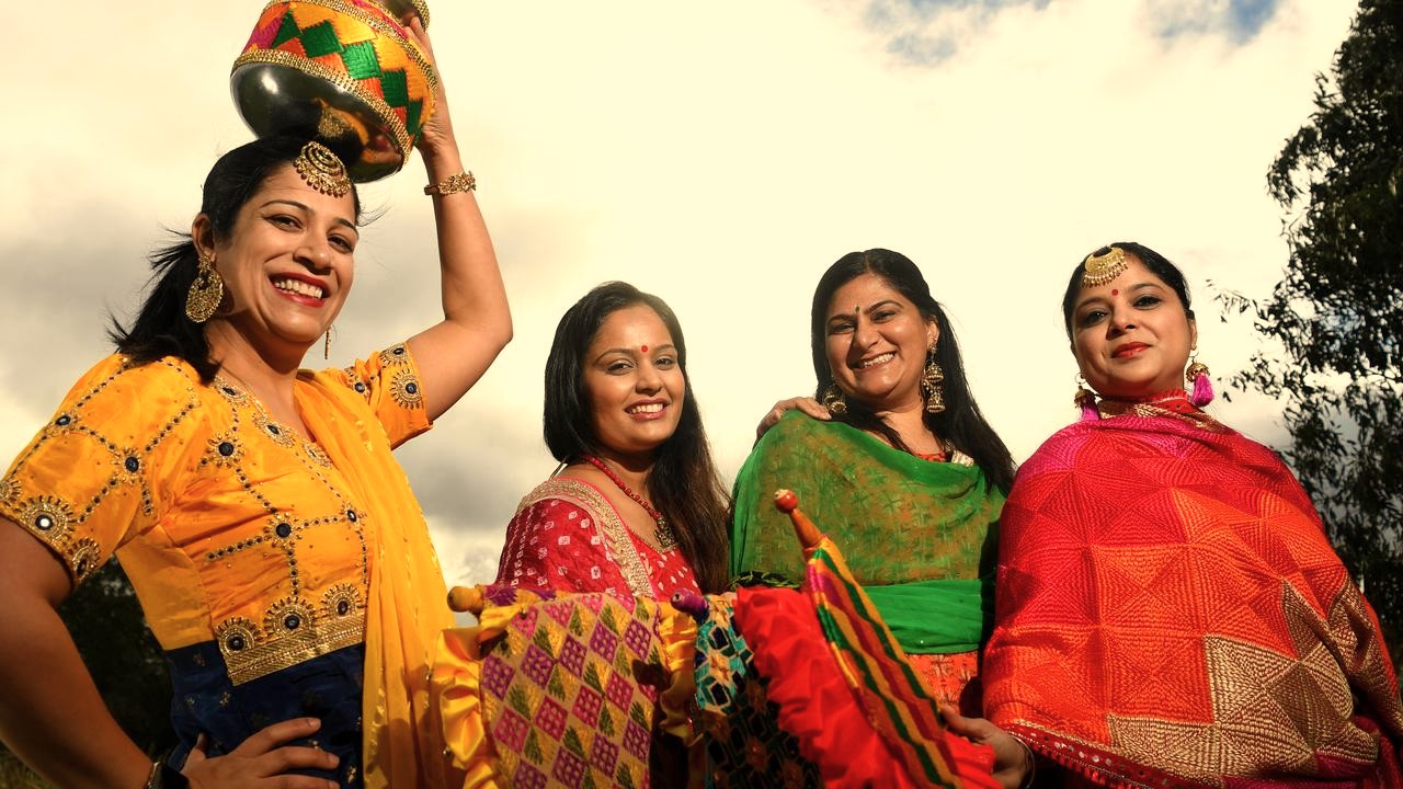 Women in vibrant traditional Indian outfits celebrate a festival at Venkatappa Art Museum in Bangalore, Karnataka, India, a cultural site for tourists visiting near Mysore Palace.