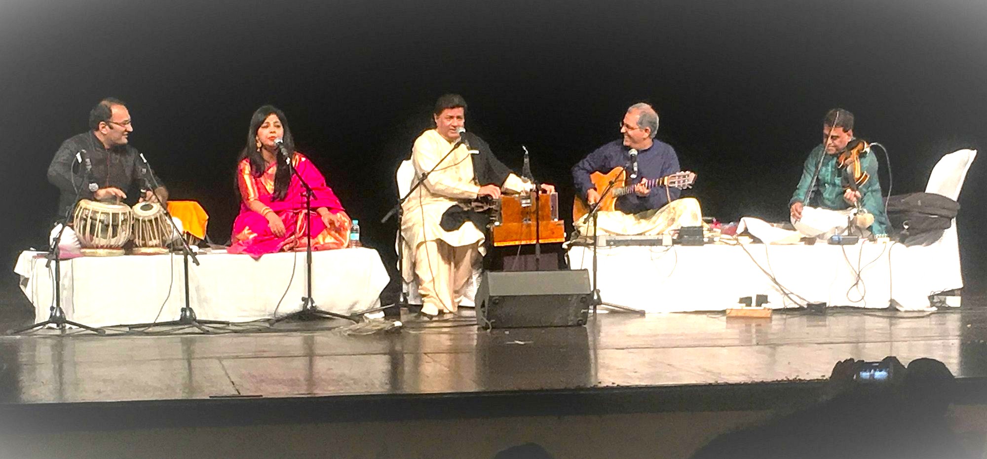 Musicians perform at Kamani Auditorium, an international performance centre in Delhi, India, a city known for UNESCO sites like Humayun's Tomb, the Red Fort, and Qutub Minar.