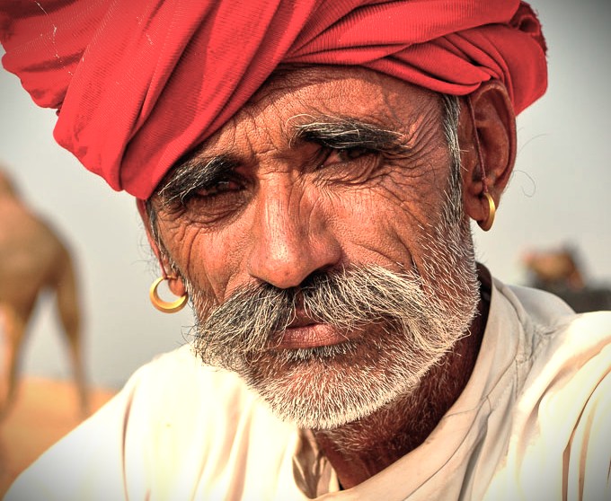 A striking portrait of a man in a red turban, reflecting the culture of India celebrated at Delhi's Kamani Auditorium, an international performance centre near UNESCO sites Humayun's Tomb, Red Fort, and Qutub Minar.