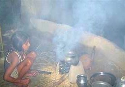 Young girl cooks using a Kids Health India Smokeless Stove Project in a smoky kitchen in Kodaikanal, Palani Hills, Tamil Nadu, South India, improving health.