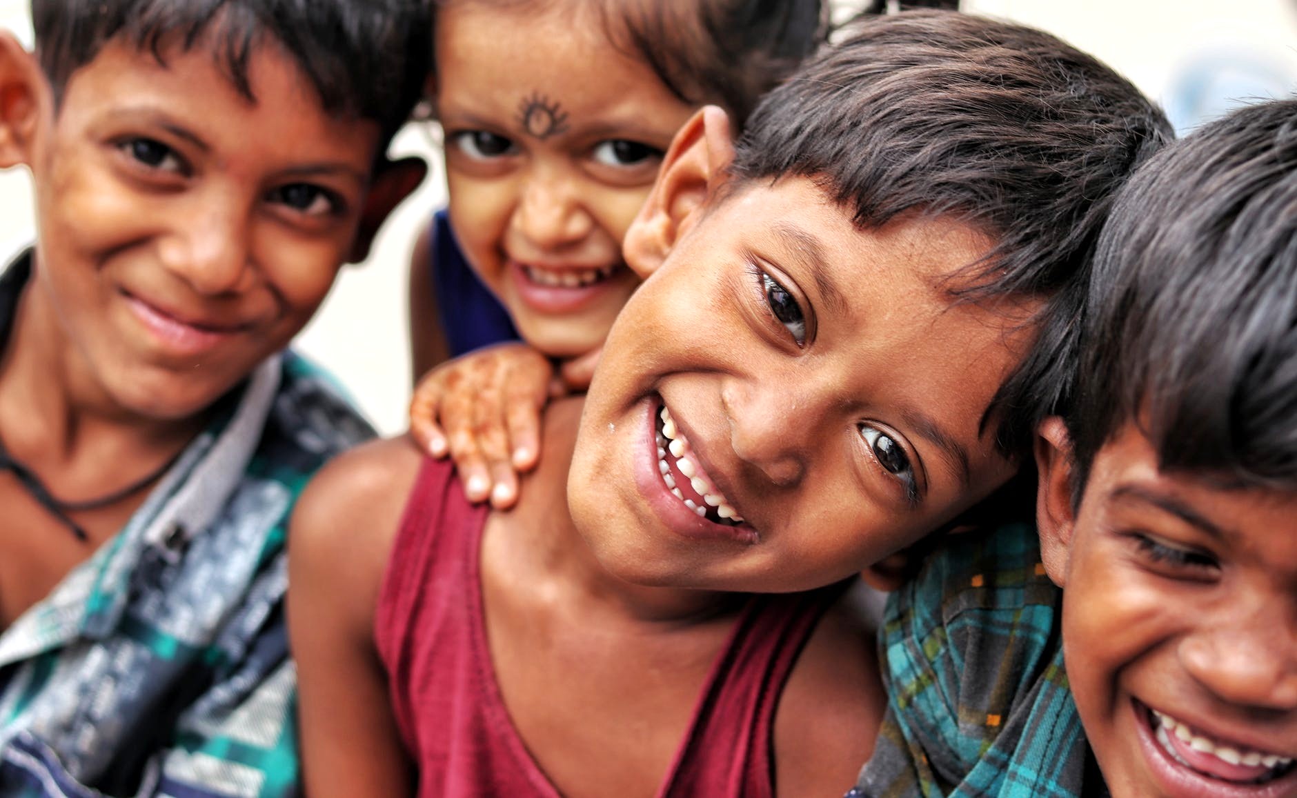 Four smiling children from Kodaikanal’s Palani Hills in Tamil Nadu, South India, benefit from the Kids Health India Smokeless Stove Project, improving health and well-being.