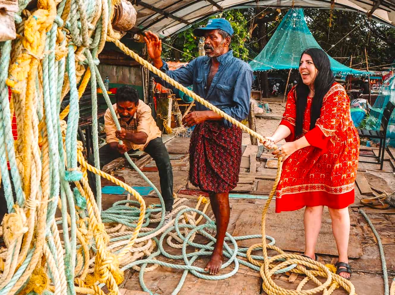 Three fishermen pulling ropes at Kochi’s iconic Chinese fishing nets in Kerala, South India illustrate cooperative maritime tradition, vibrant coastal livelihood, nautical energetic teamwork, rustic dock ambience and authentic heritage.
