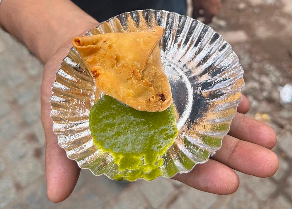 Enjoy a crispy samosa with tangy green chutney beside Kodai Lake Kulam in Kodaikanal’s Palani Hills, Tamil Nadu, South India’s vibrant, bustling food markets.