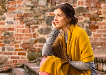 Thoughtful female traveler sits against a rustic brick wall in the courtyard of Koodal Azhagar Temple in Madurai, Tamil Nadu, South India, evoking serene reflection amid vibrant historic temple heritage. Thoughtful female traveler sits against a rustic brick wall in the courtyard of Koodal Azhagar Temple in Madurai, Tamil Nadu, South India, evoking serene reflection amid vibrant historic temple heritage.