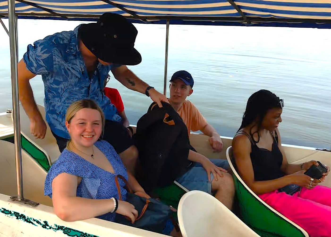 Smiling friends drift across Lake Pichola in a traditional Shikara boat, soaking Rajasthan’s sunset views of Udaipur’s palaces, enjoying India’s serene lakeside heritage tour experience with local hospitality and charm.