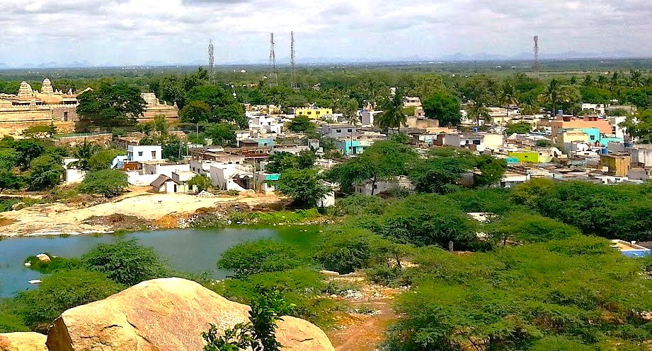 This view of Lepakshi in Andhra Pradesh, India, shows the timeless relationship between the ancient temple, the surrounding village, and the landscape, a sacred site famous for its nearby hanging pillar.