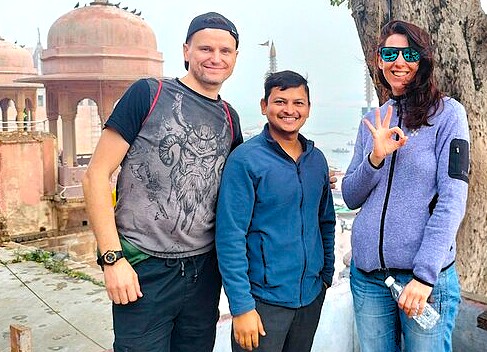 Happy tourists pose with their guide during a tour of the incredible Lepakshi Temple Complex in Andhra Pradesh, India, a historic site famous for its mysterious floating pillar.