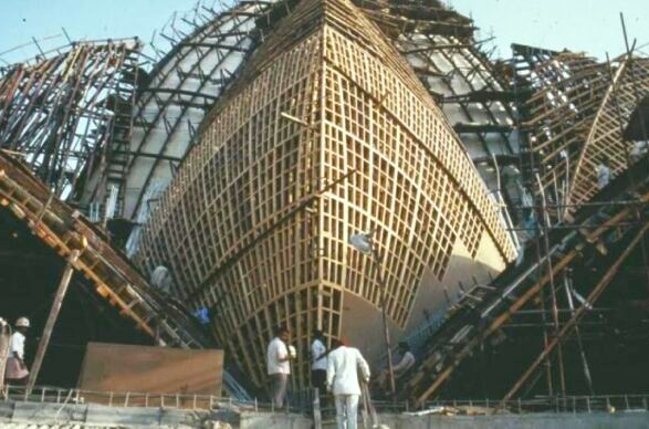 Construction workers assemble aerodynamic wooden framework scaffolding around the iconic India-Lotus Temple, New Delhi, showcasing intricate lattice design, architectural innovation, collaborative planning, and infrastructure development in sustainable heritage site construction. Construction workers assemble aerodynamic wooden framework scaffolding around the iconic India-Lotus Temple, New Delhi, showcasing intricate lattice design, architectural innovation, collaborative planning, and infrastructure development in sustainable heritage site construction.