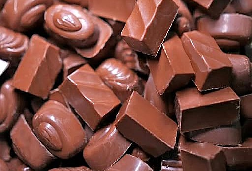 Close-up of artisanal Maofa Chocolates handcrafted in Munnar, Kerala, Southern India, showcasing glossy milk chocolate bars and exotic spice-infused truffles. Close-up of artisanal Maofa Chocolates handcrafted in Munnar, Kerala, Southern India, showcasing glossy milk chocolate bars and exotic spice-infused truffles.