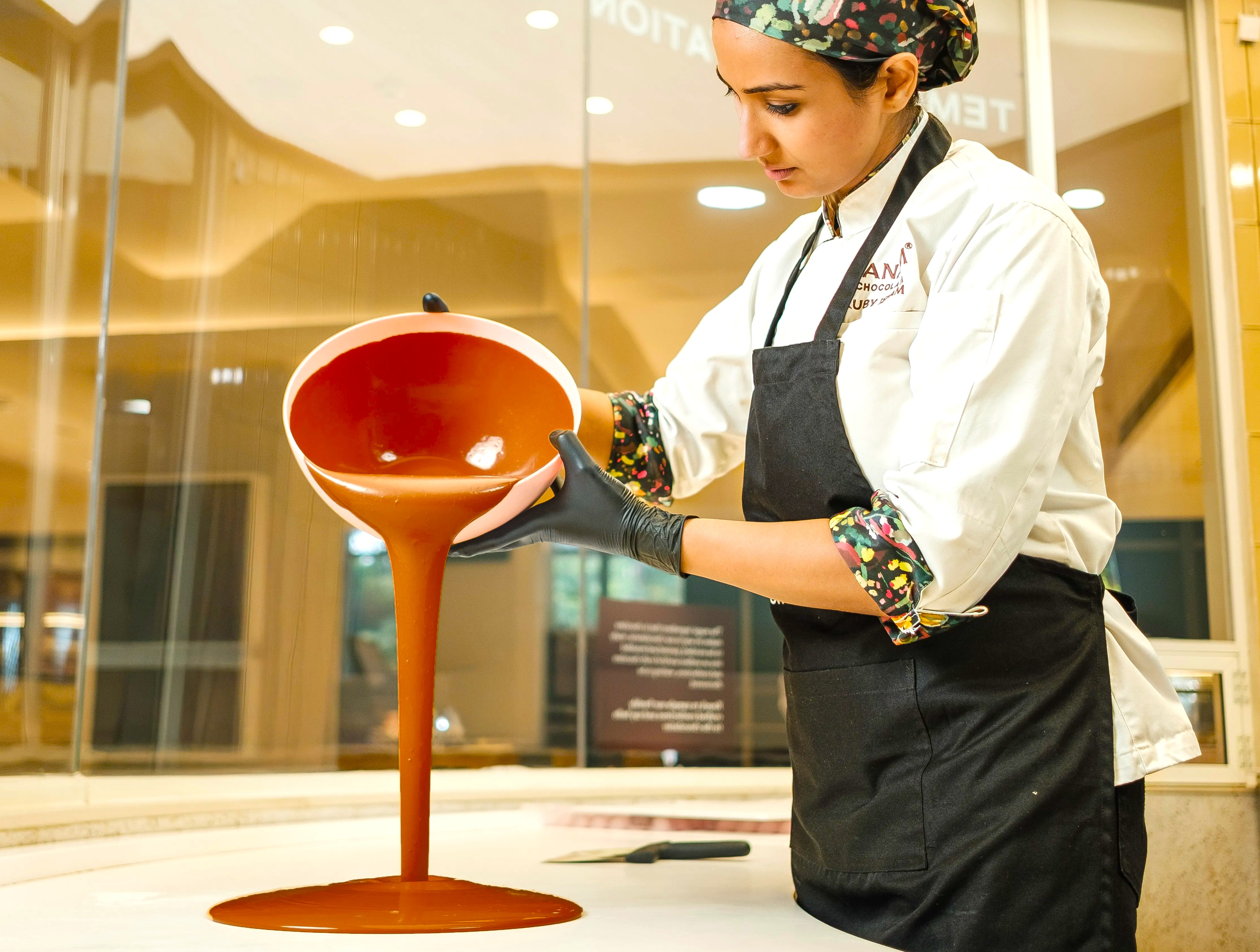 Chocolatier in Munnar, Kerala, Southern India, pouring and tempering rich Maofa Chocolates made from local cocoa on a marble table. Chocolatier in Munnar, Kerala, Southern India, pouring and tempering rich Maofa Chocolates made from local cocoa on a marble table.