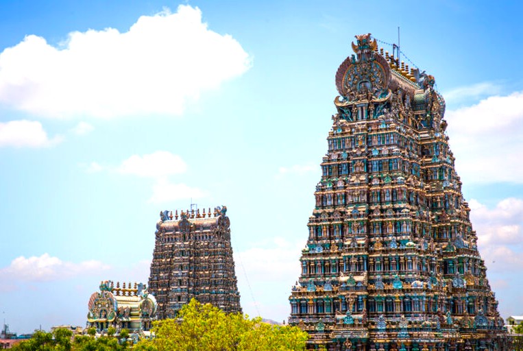 Vibrant Dravidian gopurams of the Meenakshi Amman Temple showcase intricate Hindu temple sculpture, attracting pilgrimage and heritage tourism enthusiasts to Madurai, Tamil Nadu, South India, marking an iconic religious landmark.