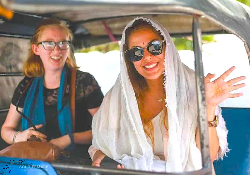 Two smiling solo female travelers enjoy a rickshaw ride in Karnataka, India, experiencing local transport while visiting the Malegitti Shivalaya Temple near the Pattadarkel-Unesco site. Two smiling solo female travelers enjoy a rickshaw ride in Karnataka, India, experiencing local transport while visiting the Malegitti Shivalaya Temple near the Pattadarkel-Unesco site.