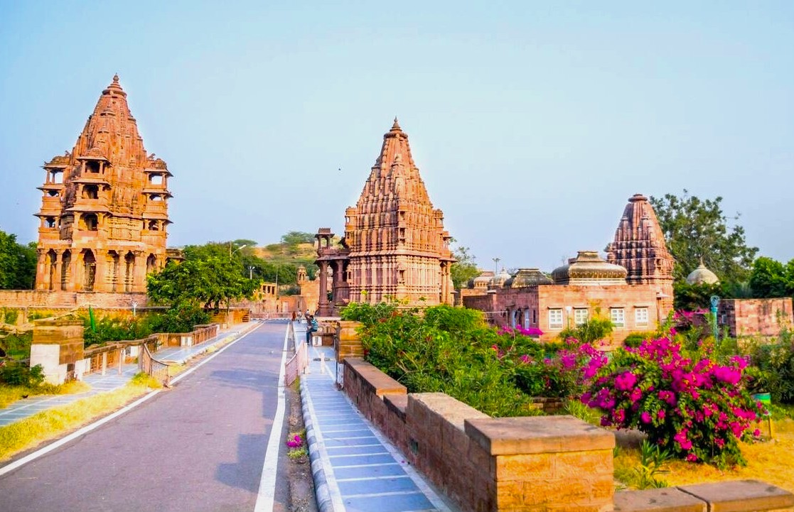 Iconic ancient sandstone temples at Mandore Gardens in Jodhpur, Rajasthan, India showcase intricate heritage architecture, lush landscaped gardens, historic cenotaphs, vibrant bougainvillea, cultural landmark attracting travelers and photographers worldwide annually. Iconic ancient sandstone temples at Mandore Gardens in Jodhpur, Rajasthan, India showcase intricate heritage architecture, lush landscaped gardens, historic cenotaphs, vibrant bougainvillea, cultural landmark attracting travelers and photographers worldwide annually.
