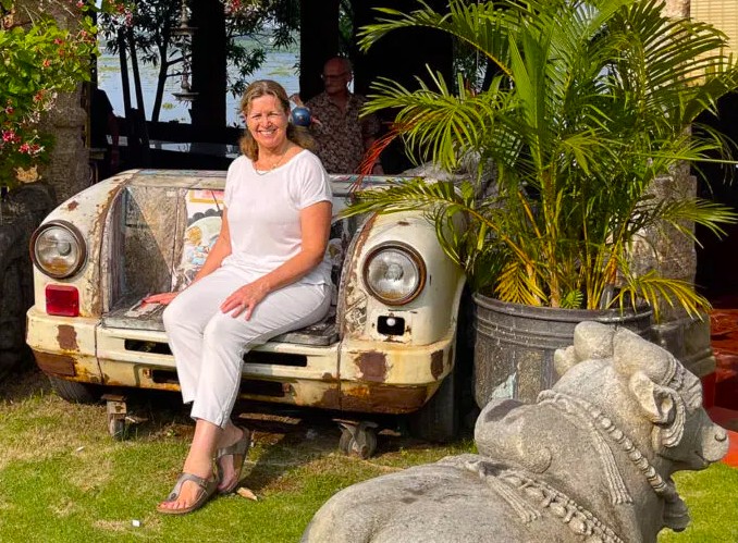 Smiling tourist seated on a vintage vehicle bench beside a stone sculpture in the garden at Mattancherry Palace, Kochi, Kerala, South India, showcases historical heritage, artistic ambiance, and cultural charm. Smiling tourist seated on a vintage vehicle bench beside a stone sculpture in the garden at Mattancherry Palace, Kochi, Kerala, South India, showcases historical heritage, artistic ambiance, and cultural charm.