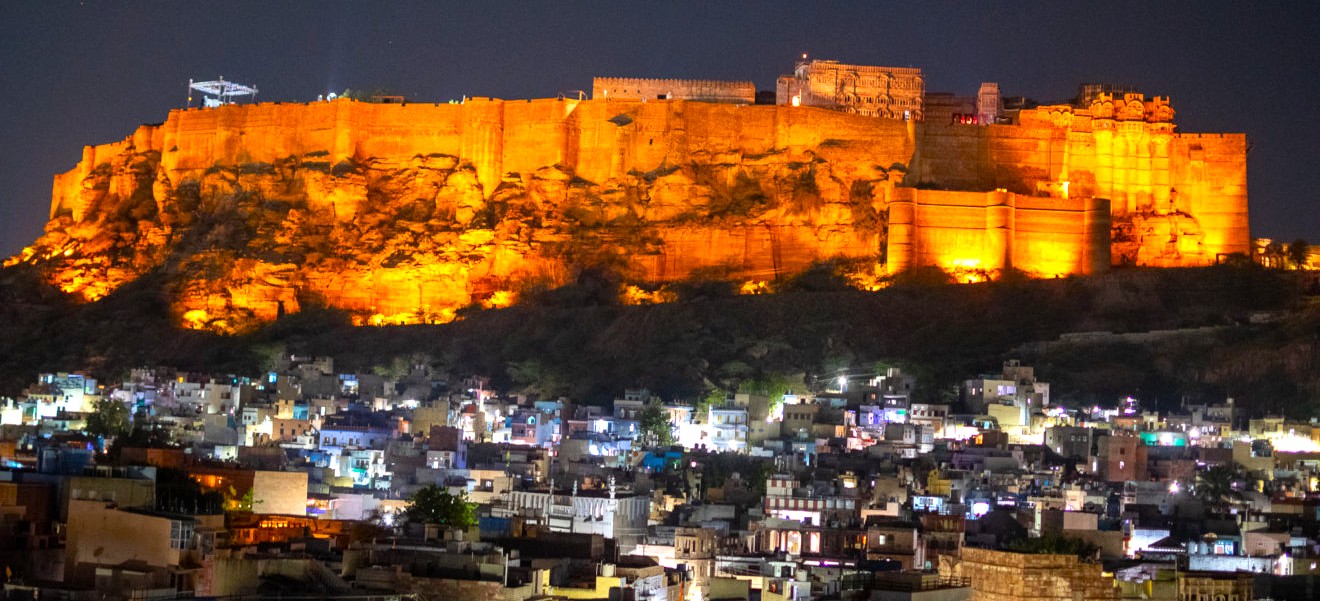 The illuminated Mehrangarh Fort overlooks the vibrant blue city of Jodhpur in Rajasthan, India, showcasing majestic iconic hilltop architecture, winding streets, historic walls, panoramic nightscape, and cultural heritage landmark charm. The illuminated Mehrangarh Fort overlooks the vibrant blue city of Jodhpur in Rajasthan, India, showcasing majestic iconic hilltop architecture, winding streets, historic walls, panoramic nightscape, and cultural heritage landmark charm.