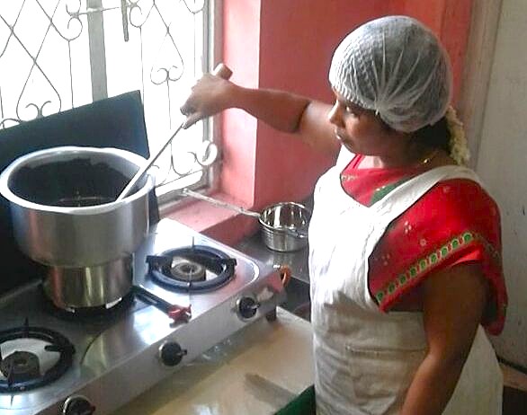 “Artisan woman stirring Moddy’s Chocolate in a traditional kitchen in Ooty, Tamil Nadu, Southern India, showcasing handcrafted chocolate making process and authentic rich local flavors.” “Artisan woman stirring Moddy’s Chocolate in a traditional kitchen in Ooty, Tamil Nadu, Southern India, showcasing handcrafted chocolate making process and authentic rich local flavors.”