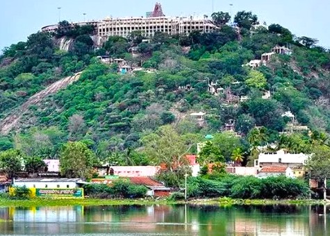 Scenic Murugan Temple: Palani Hills perched atop lush slopes overlooking a tranquil lake in Kodaikanal, Tamil Nadu, South India, invites pilgrims, tourists to experience cultural heritage, serene views, spiritual reflection.