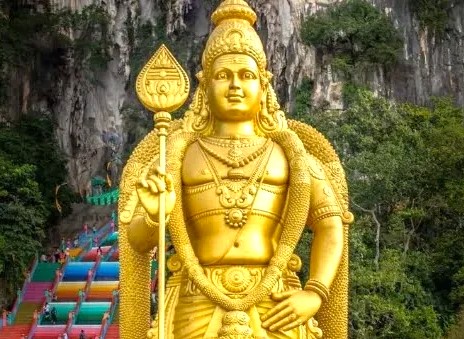 Golden statue of Lord Murugan at Palani Hills Murugan Temple in Kodaikanal, Tamil Nadu, South India, offering serene pilgrimage, cultural heritage, panoramic views, vibrant rainbow stairs, and lush hillside sanctuary.