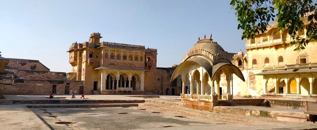 Panoramic courtyard of Nagaur Fort in Rajasthan, India, showcasing intricate domed pavilions, arched corridors, and sandstone walls against the golden dunes of the Thar Desert under a clear blue sky. Panoramic courtyard of Nagaur Fort in Rajasthan, India, showcasing intricate domed pavilions, arched corridors, and sandstone walls against the golden dunes of the Thar Desert under a clear blue sky.
