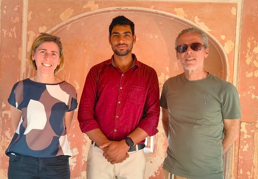 Three travelers pose indoors against a weathered wall at Nahargarh Fort in Jaipur, Rajasthan, India, highlighting cultural heritage, architectural details, guided sightseeing, vibrant history, and immersive unforgettable scenic tourism experiences.