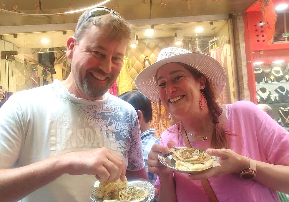 Smiling tourists devour local Indian street food, enjoying culinary immersion near the monolithic Nandi Bull Lepakshi and the ancient UNESCO site of Pattadakal. Smiling tourists devour local Indian street food, enjoying culinary immersion near the monolithic Nandi Bull Lepakshi and the ancient UNESCO site of Pattadakal.