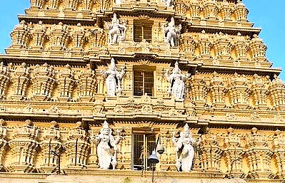 Intricate Dravidian carvings adorn the Nandi Bull Temple gopuram in Mysore, Karnataka, India, showcasing sacred bovine iconography, divine guardianship, vibrant sculptures, and historic spiritual architecture.